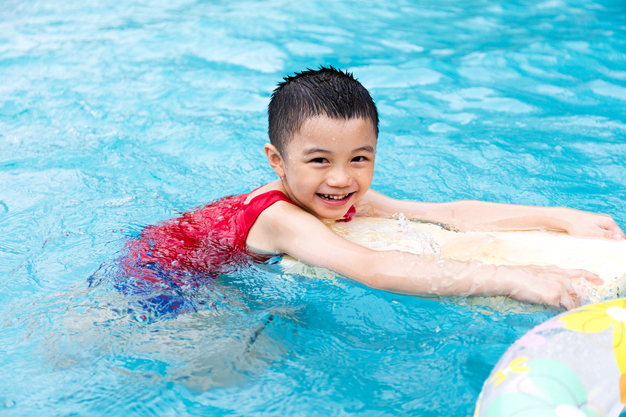 Happy Asian Chinese Little Boy Swimming With Floating Board